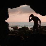 silhouette of man in cave