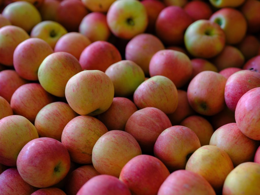 a pile of red and yellow apples sitting on top of each other